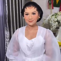 Erina Gudono mempercayakan Bennu Sorumba untuk memoles wajahnya di malam midodareni. Dalam unggahan Instagram sang makeup artist, Erina tersenyum saat memperlihatkan riasan flawless di wajahnya dalam balutan robe putih transparan. Foto: dok. Instagram @bennusorumba