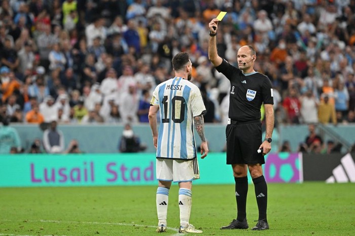Spanish referee Antonio Mateu Lahoz shows a yellow card to Argentinas forward #10 Lionel Messi during the Qatar 2022 World Cup quarter-final football match between Netherlands and Argentina at Lusail Stadium, north of Doha, on December 9, 2022. (Photo by Alberto PIZZOLI / AFP) (Photo by ALBERTO PIZZOLI/AFP via Getty Images)