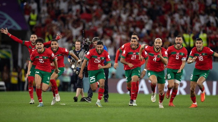 AR-RAYYAN, QATAR - DECEMBER 06: Morocco players run to winning penalty goalscorer Achraf Hakimi of Morocco and Morocco goalkeeper Yassine Bounou as they beat Spain on penalties during the FIFA World Cup Qatar 2022 Round of 16 match between Morocco (0) and Spain (0) (Morocco win 3-0 on penalties) at Education City Stadium on December 06, 2022 in Ar-Rayyan, Qatar. (Photo by Simon Bruty/Anychance/Getty Images)