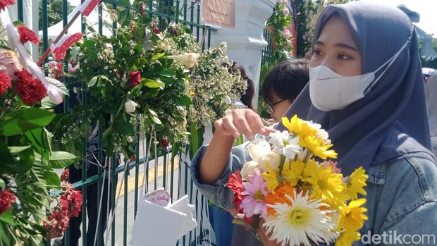 Bunga ucapan selamat dicabuti warga yang tak bisa masuk ke Puro Mangkunegaran. Mereka ingin pulang membawa kenangan tasyakuran Kaesang Pangarep dan Erina Gudono.