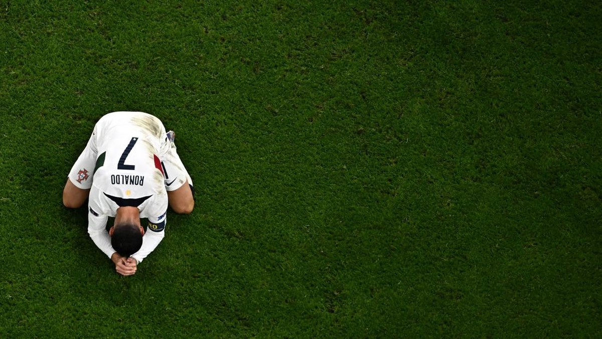 Cristiano Ronaldo tertunduk usai Portugal tersingkir di perempatfinal Piala Dunia 2022. (Foto: AFP via Getty Images/MANAN VATSYAYANA)