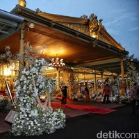 Rangkaian bunga segar langsung menyambut tamu di depan teras Pendopo.  Semua serba putih, mulai dari mawar, anggrek bulan, bunga lily, hingga baby’s breath, sehingga memberikan sentuhan elegan. Apalagi ketika berpadu apik dengan detail emas yang menghiasi arsitektur Jawa klasik dari bangunan tersebut. (Foto: Pradita Utama/detikcom)