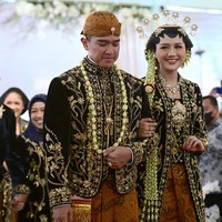 Pasangan pengantin baru ini berjalan menuju ke pelaminan.