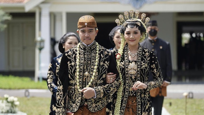 Momen Kaesang-Erina Salami Tamu Undangan Putra bungsu Presiden Joko Widodo, Kaesang Pangarep (kiri) bersama Erina Gudono (kanan) berjalan menuju lokasi resepsi Tasyakuran di Pura Mangkunegaran, Solo, Jawa Tengah, Minggu (11/12/2022). Acara Tasyakuran itu dibagi menjadi dua sesi, yakni pagi hingga siang dan sore hingga malam untuk menyambut tamu undangan, baik dari kedua mempelai, besan, ataupun tamu kenegaraan. ANTARA FOTO/Dhemas Reviyanto/nym.