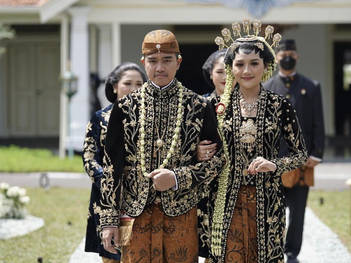 Putra bungsu Presiden Joko Widodo, Kaesang Pangarep (kiri) bersama Erina Gudono (kanan) berjalan menuju lokasi resepsi Tasyakuran di Pura Mangkunegaran, Solo, Jawa Tengah, Minggu (11/12/2022). Acara Tasyakuran itu dibagi menjadi dua sesi, yakni pagi hingga siang dan sore hingga malam untuk menyambut tamu undangan, baik dari kedua mempelai, besan, ataupun tamu kenegaraan. ANTARA FOTO/Dhemas Reviyanto/nym.