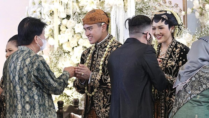 Momen Kaesang-Erina Salami Tamu Undangan Putra bungsu Presiden Joko Widodo, Kaesang Pangarep (kiri) bersama Erina Gudono (kanan) berjalan menuju lokasi resepsi Tasyakuran di Pura Mangkunegaran, Solo, Jawa Tengah, Minggu (11/12/2022). Acara Tasyakuran itu dibagi menjadi dua sesi, yakni pagi hingga siang dan sore hingga malam untuk menyambut tamu undangan, baik dari kedua mempelai, besan, ataupun tamu kenegaraan. ANTARA FOTO/Dhemas Reviyanto/nym.