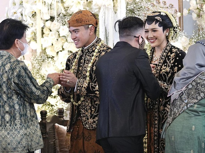 Putra bungsu Presiden Joko Widodo, Kaesang Pangarep (kiri) bersama Erina Gudono (kanan) berjalan menuju lokasi resepsi Tasyakuran di Pura Mangkunegaran, Solo, Jawa Tengah, Minggu (11/12/2022). Acara Tasyakuran itu dibagi menjadi dua sesi, yakni pagi hingga siang dan sore hingga malam untuk menyambut tamu undangan, baik dari kedua mempelai, besan, ataupun tamu kenegaraan. ANTARA FOTO/Dhemas Reviyanto/nym.