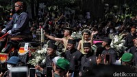 Keduanya melambaikan tangan untuk menyapa warga yang berada dipinggir jalan.