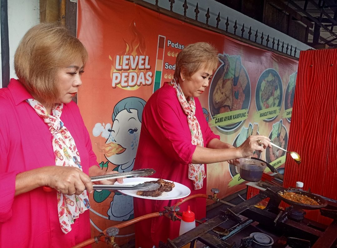 Owner Sambal Gami Mak Kembar, Evelyn Maria Wibowo (61) dan Carolyn Mari Wibowo (60) ketika tengah memasak salah satu menu pada Minggu (11/12/2022). (Ni Made Lastri Karsiani Putri-detikBali)