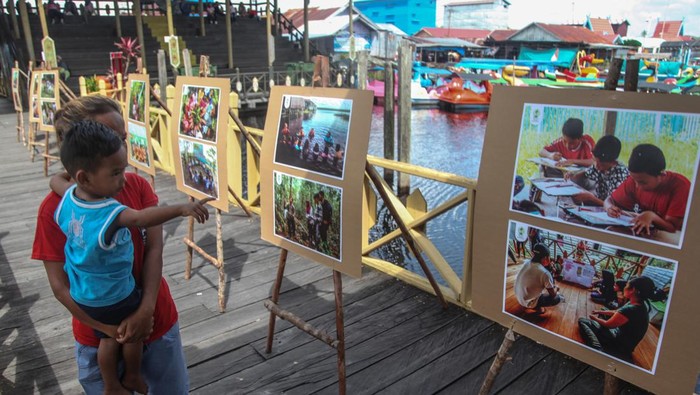 Sejumlah anak mengamati karya yang dipamerkan pada pameran foto bertajuk Festival Anak Sebangau Aku dan Alam di wisata Kereng Bangkirai, Palangka Raya, Kalimantan Tengah, Minggu (11/12/2022). Pameran yang digelar Borneo Nature Foundation (BNF) tersebut menampilkan karya gambar anak-anak di wisata itu dan 57 karya foto dokumentasi selama kegiatan mengedukasi pelestarian alam bersama Anak Sebangau serta Sebangau Ranger yang telah dibina oleh BNF selama tujuh tahun. ANTARA FOTO/Makna Zaezar/nym.