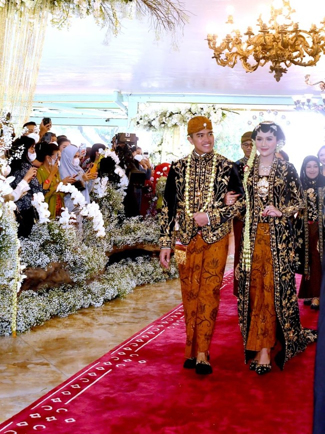 Kebaya berpotongan kutu baru tersebut tampak mewah dengan ornamen emas di seluruh kebaya. Pada bagian kutu baru dipasang bros renteng atau susun tiga. Pada bagian bawah, Erina menggunakan kain batik dengan motif khusus yaitu Sido Mukti, Sido Mulyo, dan Sido Asih, serta diwiru.Foto: Foto: Pradita Utama/detikcom