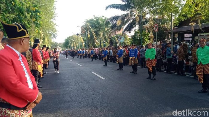 Petugas mengenakan beskap berjaga di depan Puro Mangkunegaran Solo, Minggu (11/12/2022).