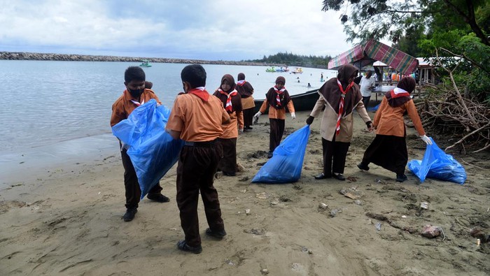 Anggota pramuka mengangkat kantong berisi berbagai jenis sampah plastik di pantai wisata Ulee Lheue, Banda Aceh, Aceh, Minggu (11/12/2022). Gerakan bersih pantai dan cinta laut dari sampah plastik itu sebagai aksi sosial dan untuk mengedukasi pengunjung dan pedagang kuliner agar tidak membuang sampah sembarangan terutama ke laut. ANTARA FOTO/Ampelsa/nym.