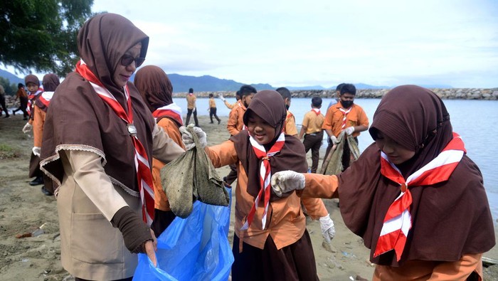 PRAMUKA AKSI BERSIH PANTAI DAN CINTA LAUT Anggota pramuka mengangkat kantong berisi berbagai jenis sampah plastik di pantai wisata Ulee Lheue, Banda Aceh, Aceh, Minggu (11/12/2022). Gerakan bersih pantai dan cinta laut dari sampah plastik itu sebagai aksi sosial dan untuk mengedukasi pengunjung dan pedagang kuliner agar tidak membuang sampah sembarangan terutama ke laut. ANTARA FOTO/Ampelsa/nym.