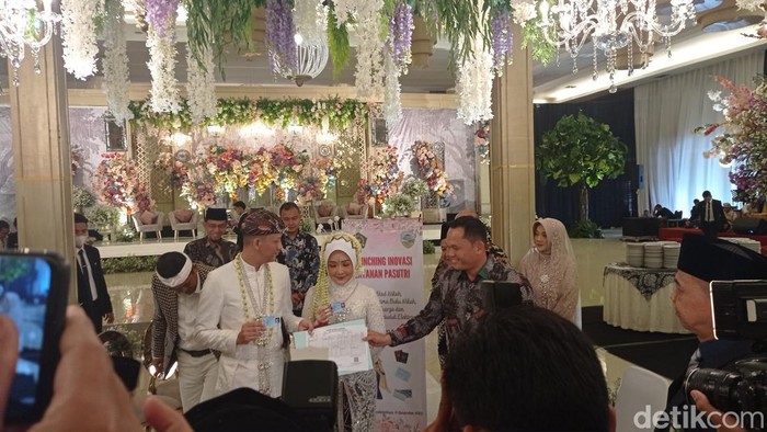 Wali Kota Tasikmalaya Cheka Virgowansyah menyerahkan kartu keluarga kepada Briptu M. Ikbal Prasetyo dan dr. Selma Hanifa yang digelar di Graha Asia Plaza