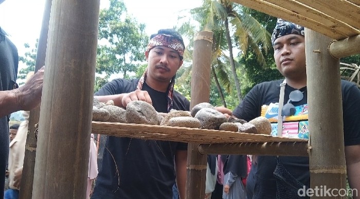Warga menyerahkan batu bawaannya untuk dijodohkan di Festival Kawin Batu.