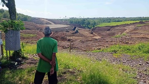 Warga sekitar saat melihat pengerjaan tol Gilimanuk-Mengwi yang masih dalam tahapan perataan lahan di Banjar Sumbermis, Desa Pekutatan, Kecamatan Pekutatan, Kabupaten Jembrana, Kamis (08/12/2022). Foto: I Putu Adi Budiastrawan