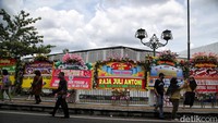 Warga melintas di depan karangan bunga ucapan selamat atas pernikahan Kaesang Pangarep dengan Erina Gudono.
