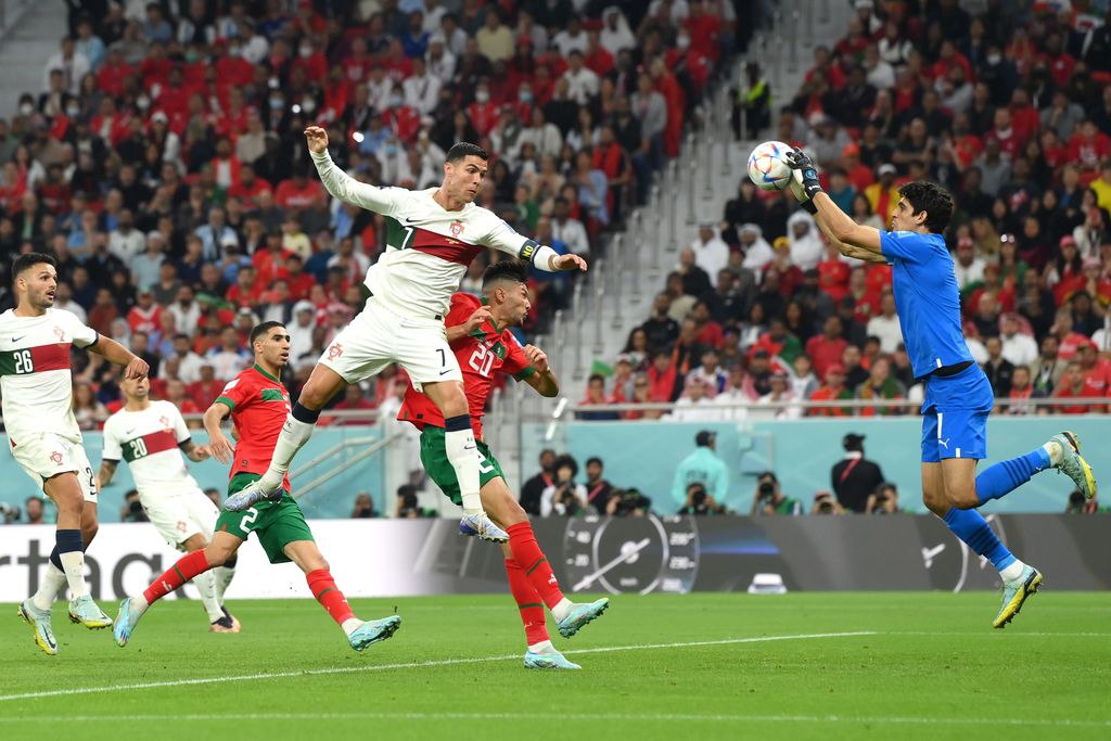 Yassine Bounou dari Maroko melakukan penyelamatan melawan Cristiano Ronaldo dari Portugal selama pertandingan perempat final Piala Dunia FIFA Qatar 2022 antara Maroko dan Portugal di Stadion Al Thumama pada 10 Desember 2022 di Doha, Qatar. (David Ramos - FIFA/FIFA via Getty Images)