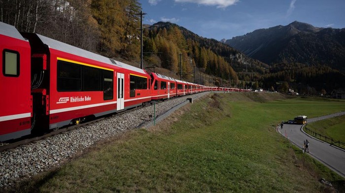 1244317095 A 1910-metre-long train with 100 cars passes by in Bergun on October 29, 2022, during a record attempt by the Rhaetian Railway (RhB) of the World's longest passenger train, to mark the Swiss railway operator's 175th anniversary. - The record attempt is carried out on the Albula Line, from Preda to Thusis, crossing one of the most spectacular railways in the world, recognised as a Unesco World Heritage Site. (Photo by Fabrice COFFRINI / AFP) (Photo by FABRICE COFFRINI/AFP via Getty Images)