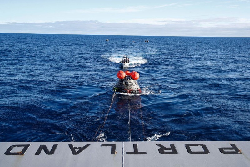 AT SEA, PACIFIC OCEAN - DECEMBER 11: U.S. Navy divers secure NASA's Orion Capsule during recovery operations after it splashed down following a successful uncrewed Artemis I moon mission on December 11, 2022 seen from aboard the U.S.S. Portland in the Pacific Ocean off the coast of Baja California, Mexico. A 26-day mission took the Orion spacecraft to the moon and back which completed a historic test flight that coincided with the 50th anniversary of the landing of Apollo 17 on the moon, the last time that NASA astronauts walked there. (Pool photo by Mario Tama/Getty Images)