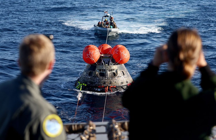 AT SEA, PACIFIC OCEAN - DECEMBER 11: U.S. Navy divers secure NASAs Orion Capsule during recovery operations after it splashed down following a successful uncrewed Artemis I moon mission on December 11, 2022 seen from aboard the U.S.S. Portland in the Pacific Ocean off the coast of Baja California, Mexico. A 26-day mission took the Orion spacecraft to the moon and back which completed a historic test flight that coincided with the 50th anniversary of the landing of Apollo 17 on the moon, the last time that NASA astronauts walked there. (Pool photo by Mario Tama/Getty Images)