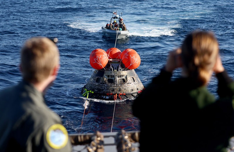 AT SEA, PACIFIC OCEAN - DECEMBER 11: U.S. Navy divers secure NASA's Orion Capsule during recovery operations after it splashed down following a successful uncrewed Artemis I moon mission on December 11, 2022 seen from aboard the U.S.S. Portland in the Pacific Ocean off the coast of Baja California, Mexico. A 26-day mission took the Orion spacecraft to the moon and back which completed a historic test flight that coincided with the 50th anniversary of the landing of Apollo 17 on the moon, the last time that NASA astronauts walked there. (Pool photo by Mario Tama/Getty Images)