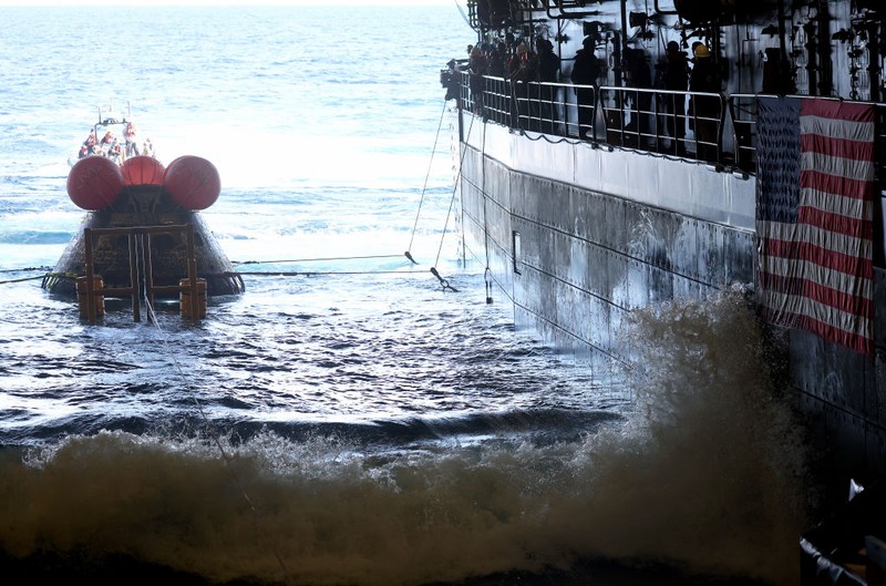 AT SEA, PACIFIC OCEAN - DECEMBER 11: U.S. Navy divers secure NASA's Orion Capsule during recovery operations after it splashed down following a successful uncrewed Artemis I moon mission on December 11, 2022 seen from aboard the U.S.S. Portland in the Pacific Ocean off the coast of Baja California, Mexico. A 26-day mission took the Orion spacecraft to the moon and back which completed a historic test flight that coincided with the 50th anniversary of the landing of Apollo 17 on the moon, the last time that NASA astronauts walked there. (Pool photo by Mario Tama/Getty Images)