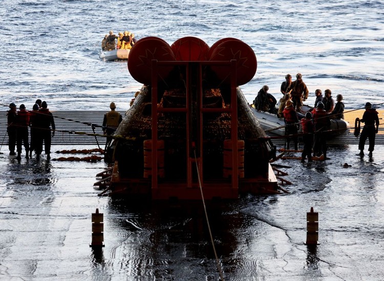 AT SEA, PACIFIC OCEAN - DECEMBER 11: U.S. Navy divers secure NASAs Orion Capsule during recovery operations after it splashed down following a successful uncrewed Artemis I moon mission on December 11, 2022 seen from aboard the U.S.S. Portland in the Pacific Ocean off the coast of Baja California, Mexico. A 26-day mission took the Orion spacecraft to the moon and back which completed a historic test flight that coincided with the 50th anniversary of the landing of Apollo 17 on the moon, the last time that NASA astronauts walked there. (Pool photo by Mario Tama/Getty Images)