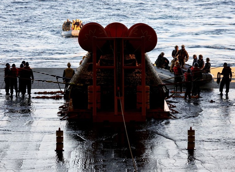 AT SEA, PACIFIC OCEAN - DECEMBER 11: U.S. Navy divers secure NASA's Orion Capsule during recovery operations after it splashed down following a successful uncrewed Artemis I moon mission on December 11, 2022 seen from aboard the U.S.S. Portland in the Pacific Ocean off the coast of Baja California, Mexico. A 26-day mission took the Orion spacecraft to the moon and back which completed a historic test flight that coincided with the 50th anniversary of the landing of Apollo 17 on the moon, the last time that NASA astronauts walked there. (Pool photo by Mario Tama/Getty Images)