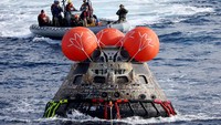 AT SEA, PACIFIC OCEAN - DECEMBER 11: NASAs Orion Capsule descends toward splash down after a successful uncrewed Artemis I Moon Mission on December 11, 2022 seen from aboard the U.S.S. Portland in the Pacific Ocean off the coast of Baja California, Mexico. A 26-day mission took the Orion spacecraft to the moon and back which completed a historic test flight that coincided with the 50th anniversary of the landing of Apollo 17 on the moon, the last time that NASA astronauts walked there. (Pool photo by Mario Tama/Getty Images)