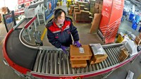 Para karyawan juga sibuk menyortir paket yang akan dikirim. VCG/VCG via Getty Images.