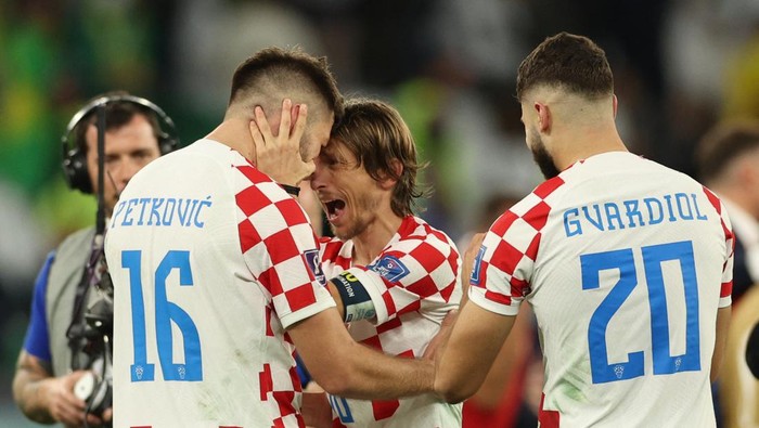 Croatias midfielder #10 Luka Modric (C) celebrates with Croatias forward #16 Bruno Petkovic (L) and Croatias defender #20 Josko Gvardiol after they won the Qatar 2022 World Cup quarter-final football match between Croatia and Brazil at Education City Stadium in Al-Rayyan, west of Doha, on December 9, 2022. (Photo by Adrian DENNIS / AFP) (Photo by ADRIAN DENNIS/AFP via Getty Images)