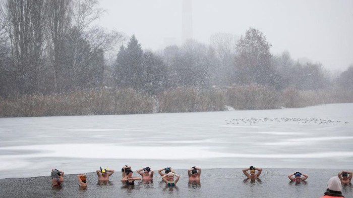 Badai salju menerjang Polandia selama tiga hari. Sejumlah warga nekat berenang di danau memakai pakaian bikini dan boxer.