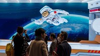 Para pengunjung berdiri di bawah sebuah bola besar yang menggambarkan model bumi. Pameran yang diadakan setiap tahun ini merupakan hal yang luar biasa bagi masyarakat Hong Kong.
