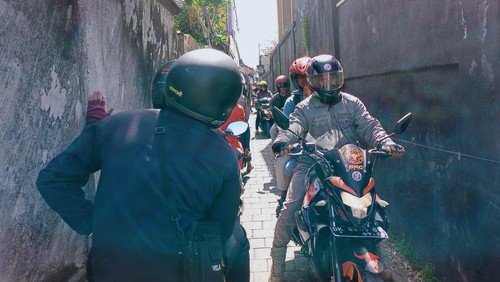 Pengendara motor melintas di gang warga sehingga macet di Kelurahan Kapal Badung, gegara ada perbaikan jalan, Senin (12/12/2022).