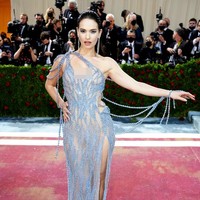 Lily James berbalut gaun transparan berpotongan asimetris rancangan Versace untuk MET Gala 2022. Banyak aksen busana yang menonjolkan keseksiannya, seperti garis leher rendah hingga belahan paha tinggi. Foto: Getty Images