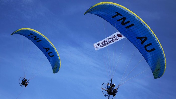 Atraksi Pesawat Tempur Sukhoi Meriahkan Hari Nusantara di Wakatobi Prajurit TNI AU menaiki paramotor saat puncak peringatan Hari Nusantara 2022 di Wakatobi, Sulawesi Tenggara, Selasa (13/12/2022). Prajurit TNI menampilkan beberapa kegiatan seperti terjun payung, paramotor serta parade kapal perang pada acara tersebut. ANTARA FOTO/Jojon/aww.