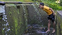 Seorang pria mencuci wajahnya dari air di Munduk, Bali, Indonesia.