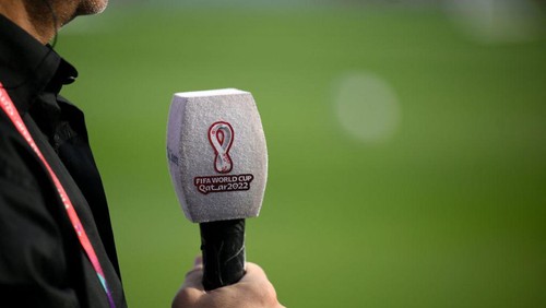 A journalist holds a mic during an England training session at Al Wakrah SC Stadium in Al Wakrah, south of Doha, on December 1, 2022, during the Qatar 2022 World Cup football tournament. (Photo by Nicolas TUCAT / AFP) (Photo by NICOLAS TUCAT/AFP via Getty Images)