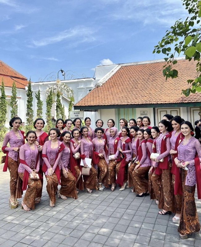 Wanita kelahiran 19 Agustus 1997 ini memperlihatkan 34 wanita cantik yang mewakili setiap provinsi di Indonesia tampil sebagai bridesmaid di pernikahan Erina dan Kaesang. 34 Puteri Indonesia 2022 terlihat anggun dan feminin menggunakan kebaya kutubaru lengkap dengan konde tradisional dan berfoto bersama di Pura Mangkunegaran, Solo.  Foto: Dok. Instagram @ginasinaga.