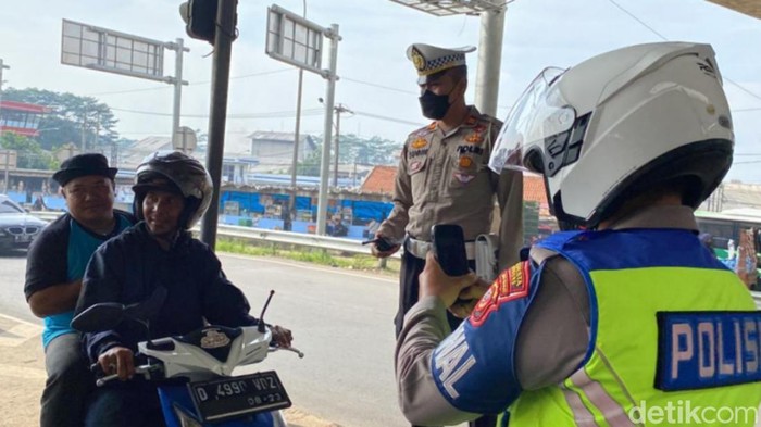 Polisi memotret pengendara yang melanggar aturan di kawasan Cileunyi, Kota Bandung.
