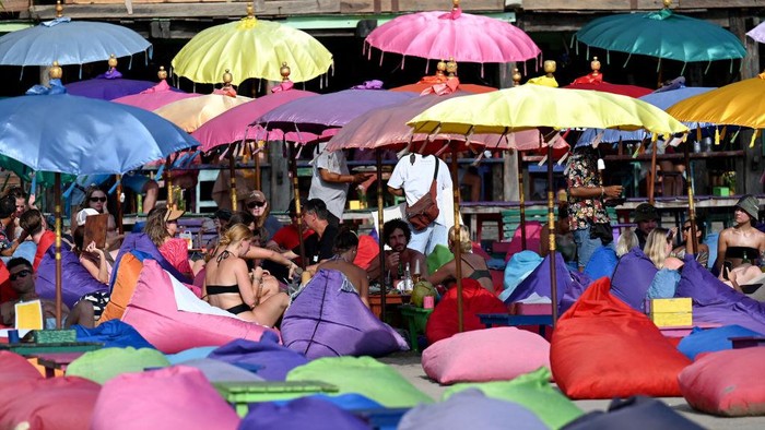 Foreign tourists enjoy their holiday on a beach in Seminyak, Badung regency on Indonesia resort island of Bali on December 7, 2022. (Photo by SONNY TUMBELAKA / AFP) (Photo by SONNY TUMBELAKA/AFP via Getty Images)