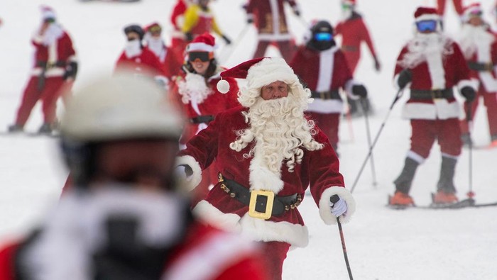 Rombongan Sinterklas Asik Main Ski Jelang Natal Three hundred plus skiers and snowboarders dressed as Santa Clause, and some other holiday characters, take off from the top of the mountain as they take part in the Santa Sunday event at Sunday River Resort in Newry, Maine on December 11, 2022. Money raised by the the event goes towards the River Fund Maine charity. (Photo by Joseph Prezioso / AFP) (Photo by JOSEPH PREZIOSO/AFP via Getty Images)