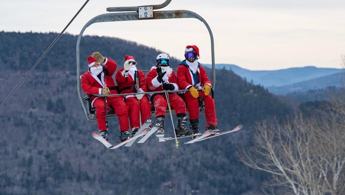 Three hundred plus skiers and snowboarders dressed as Santa Clause, and some other holiday characters, take off from the top of the mountain as they take part in the Santa Sunday event at Sunday River Resort in Newry, Maine on December 11, 2022.  Money raised by the the event goes towards the River Fund Maine charity. (Photo by Joseph Prezioso / AFP) (Photo by JOSEPH PREZIOSO/AFP via Getty Images)
