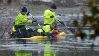Petugas melakukan pencarian korban jatuhnya sejumlah anak ke dalam danau Es di Babbs Mill Park, Solihull, Inggris, Senin (12/12/2022).