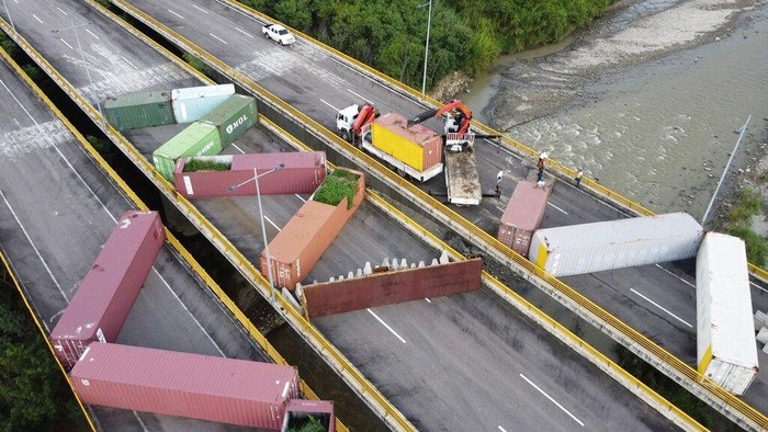 Venezuelan personnel remove containers that were blocking the Tienditas International Bridge, the international border between Venezuela and Colombia, in Cucuta, Colombia, Tuesday, Dec.12, 2022. Venezuelan President Nicolás Maduro announced his decision to fully open the border crossings with Colombia starting in January. (AP Photo/Maria Baron)
