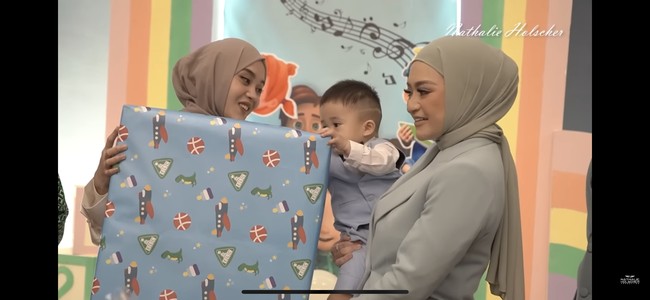 Tak datang dengan tangan kosong, Putri Delina juga membawa hadiah yang cukup besar untuk Adzam. Adzam yang melihatnya pun tampak tak sabar ingin langsung membuka kado pemberian Putri Delina. Foto: YouTube/Nathalie Holscher