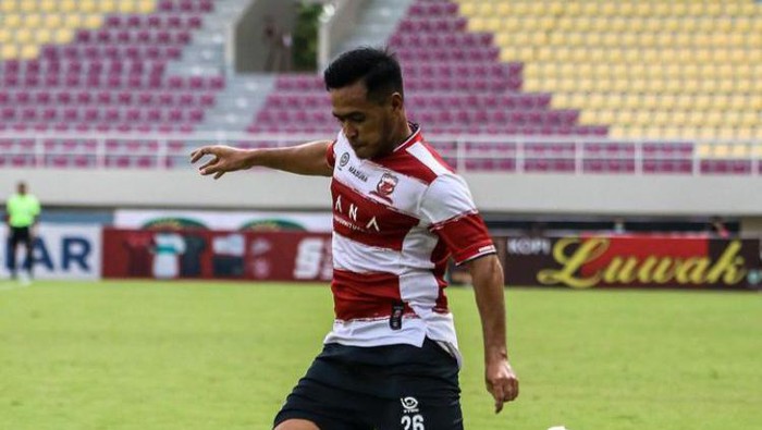 Bek Madura United Nova Setya Sasongko  mengambil  ancang-ancang menendang bola