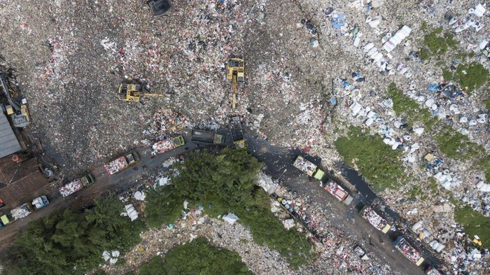 Foto Udara Antrean Panjang Truk Sampah Akibat Longsor di TPA Burangkeng Foto udara sejumlah truk pengangkut sampai parkir dalam antrean bongkar muat sampah di Tempat Pembuangan Akhir (TPA) Burangkeng, Kabupaten Bekasi, Jawa Barat, Rabu (14/12/2022). Menurut petugas, proses bongkar muat sampah terhambat dan terkendala akibat akses jalan yang tertutup longsoran sampah pada Sabtu(10/12) kemarin dan saat ini sedang dalam proses pengangkutan menggunakan alat berat untuk membersihkan longsoran sampah. ANTARA FOTO/Fakhri Hermansyah/wsj.
